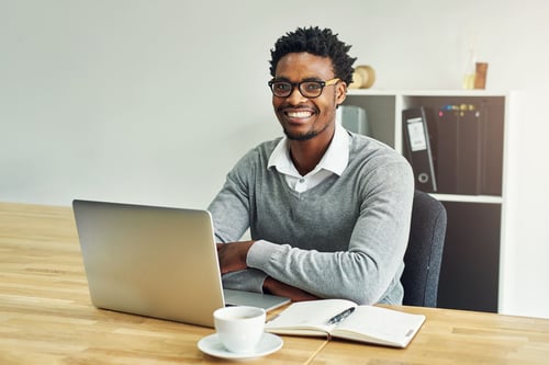 Homme assis sur son bureau avec le sourire
