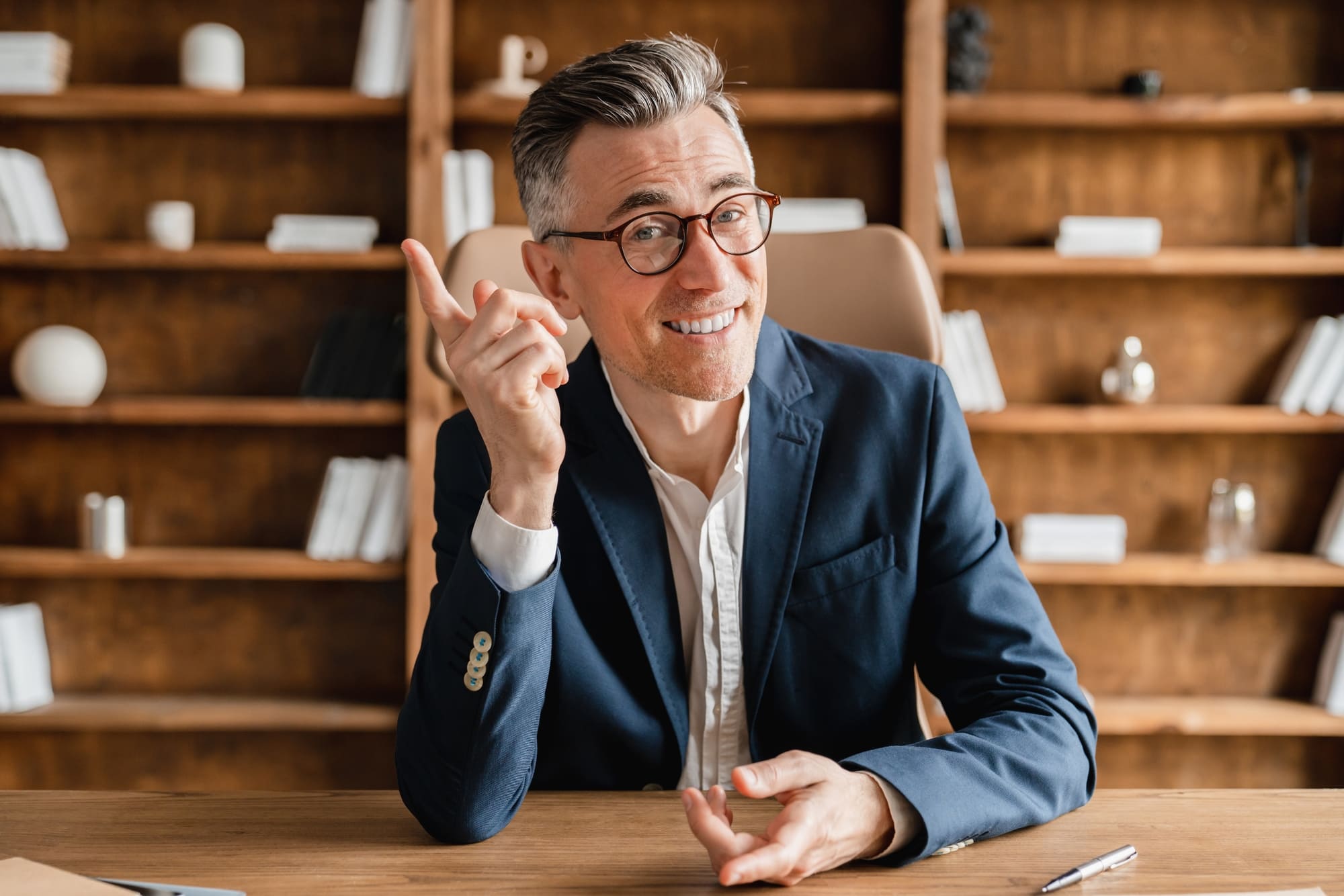 Negociateur immobilier assis sur son bureau avec le sourire
