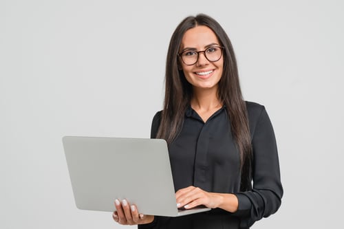 Femme souriant en tenant debout son ordinateur portable ouvert