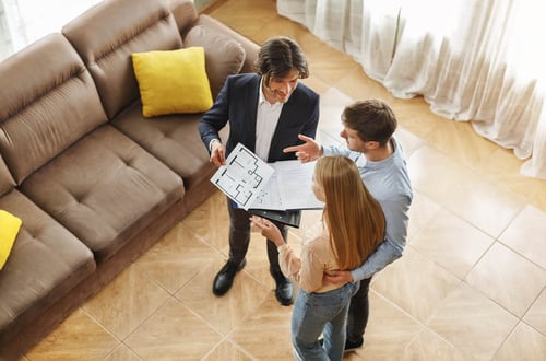 Comment devenir mandataire immobilier - Mandataire immobilier montre les plans a un couple