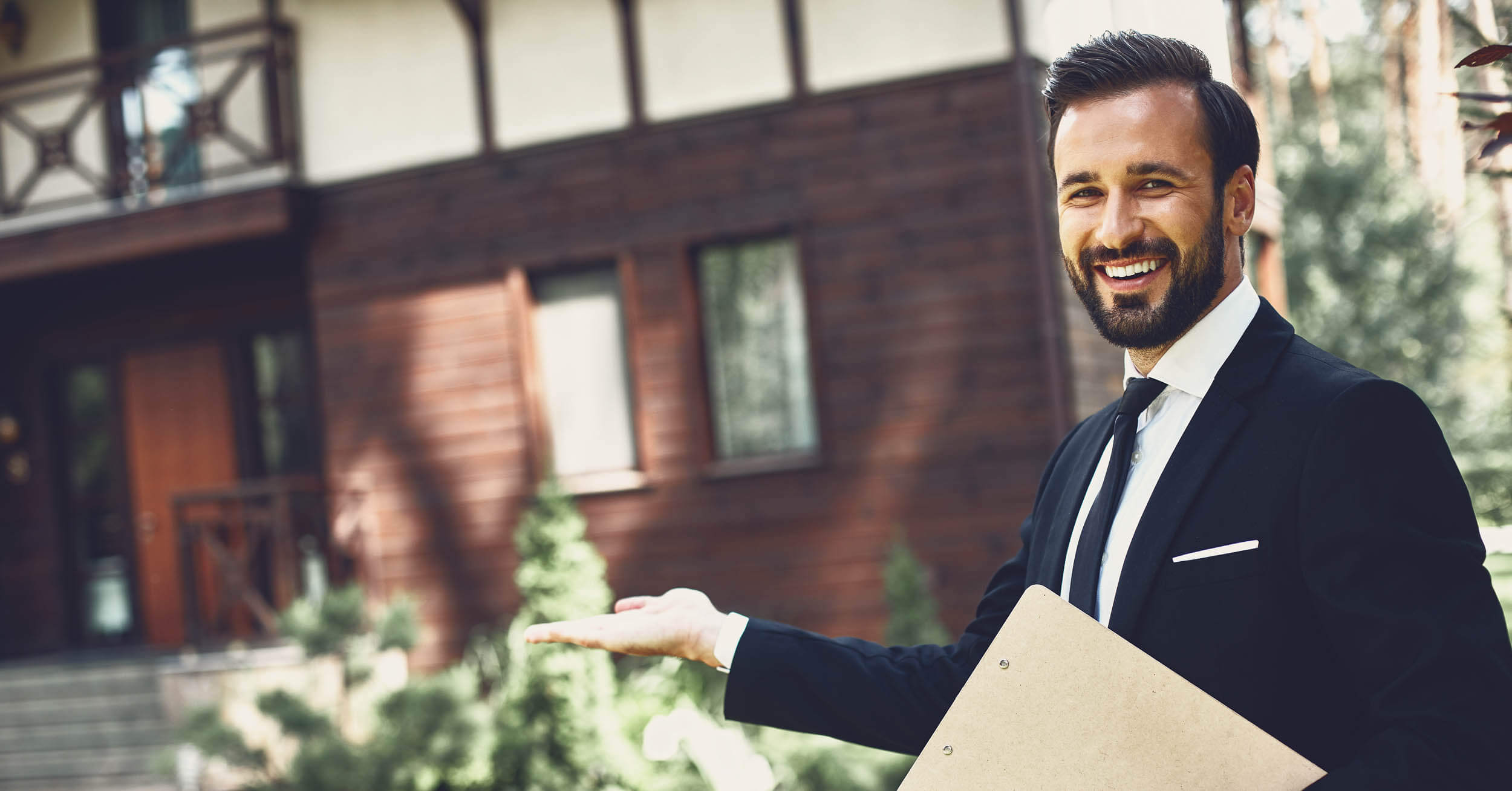 Avantages inconvénients agent mandataire immobilier - Agent immobilier souriant présentant dehors une maison